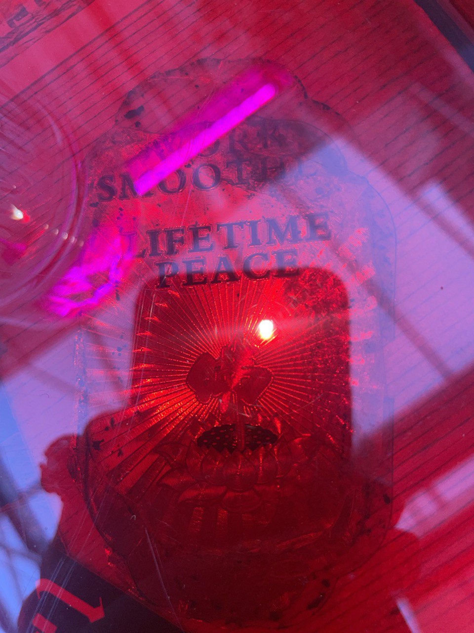 Red light, transparent materials, reflections, text fragments, possibly a lamp or light fixture, glowing, circular patterns, intricate design.